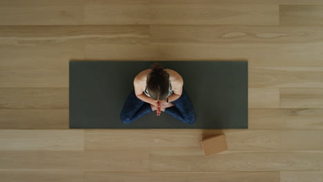 Oben-Gesehene-Yoga-Frau-Praktiziert-Lotus-Pose-Im-Trainingsstudio-Und-Genießt-Einen-Gesunden-Lebensstil,-Meditationsübungstraining-Auf-Einer-Trainingsmatte