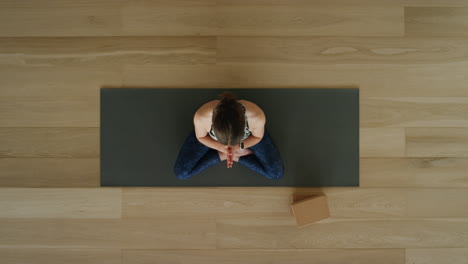 above view yoga woman practicing lotus pose in workout studio enjoying healthy lifestyle meditation practice training on exercise mat