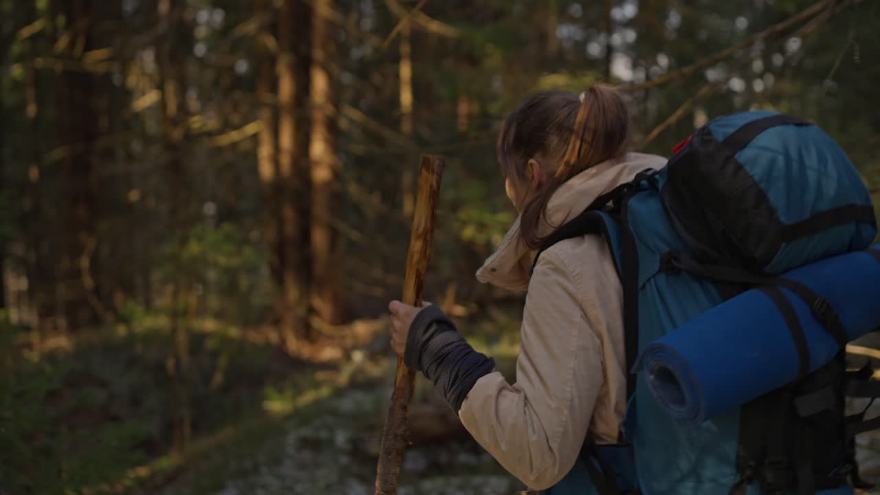 Woman hiking in the forest with a backpack