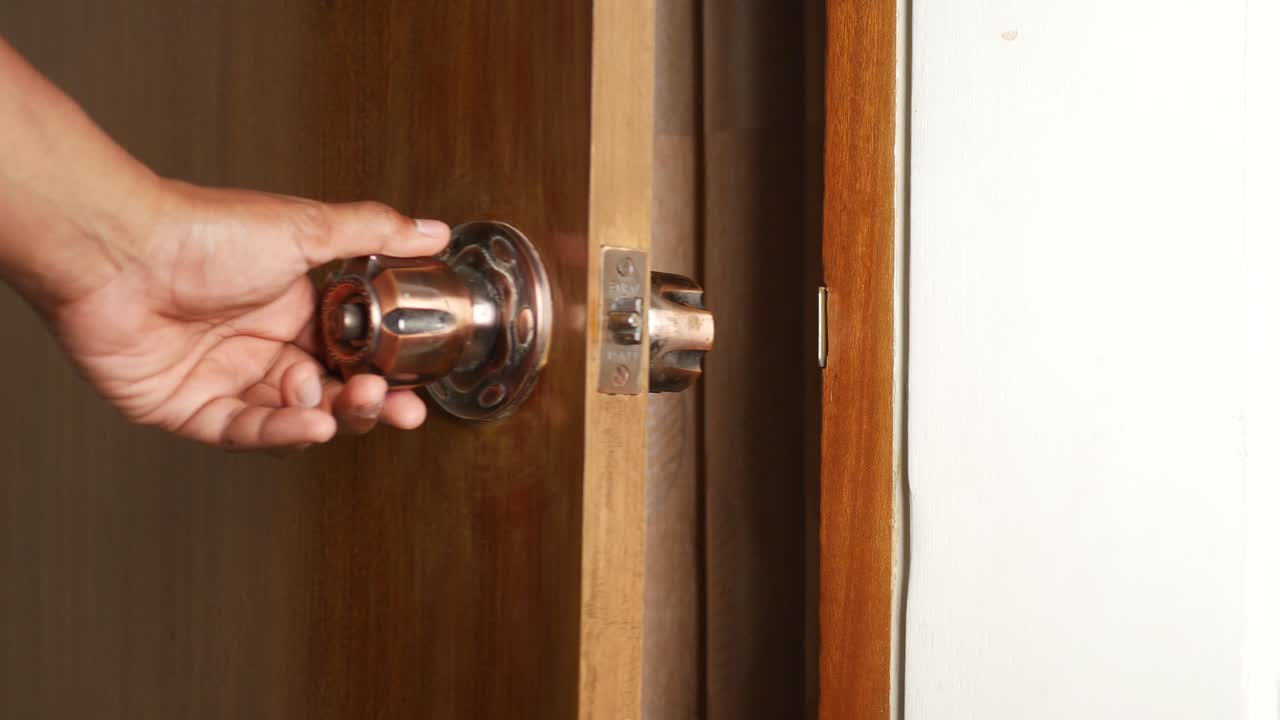 persona que abre una puerta de madera