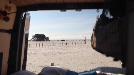 view of sankt-peter ording from a parked van - vanlife in a seaside resort in germany - dolly-out shot