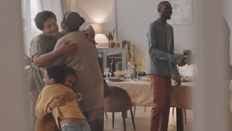 a family gathers for a celebration, hugging and laughing together.