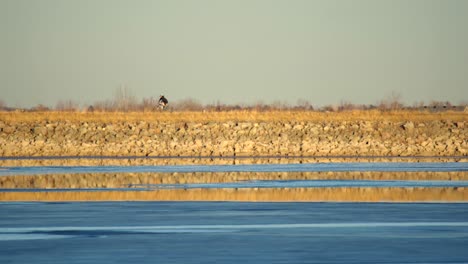 Bikers-riding-along-a-trail-with-lake-view