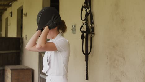 caucasian woman putting on her helmet