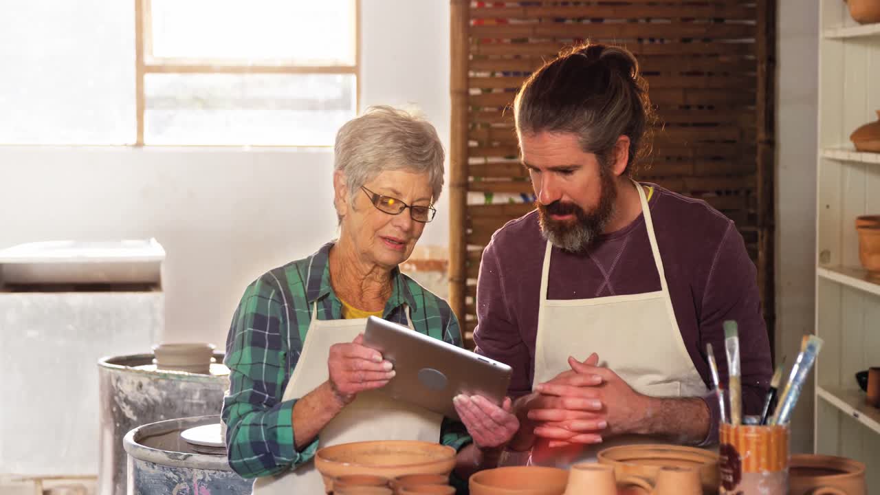 hombre y mujer alfareros usando tableta digital