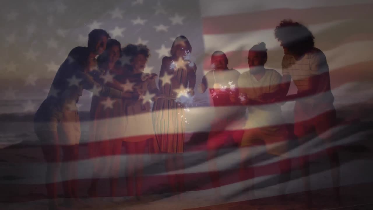bandera estadounidense ondeando contra un grupo de amigos disfrutando con chispas en la playa