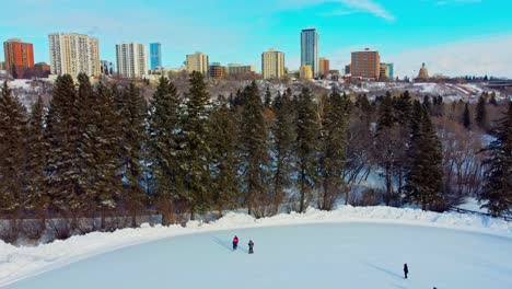 invierno en victoria park pista de patinaje doble cita durante -35 grados centígrados por la tarde con un horizonte de fondo con vista al valle ice park the hendrix, la legislatura, crestview tower condominium edm3-4