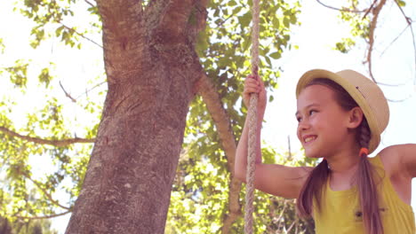 Happy little girl on a swing in the park