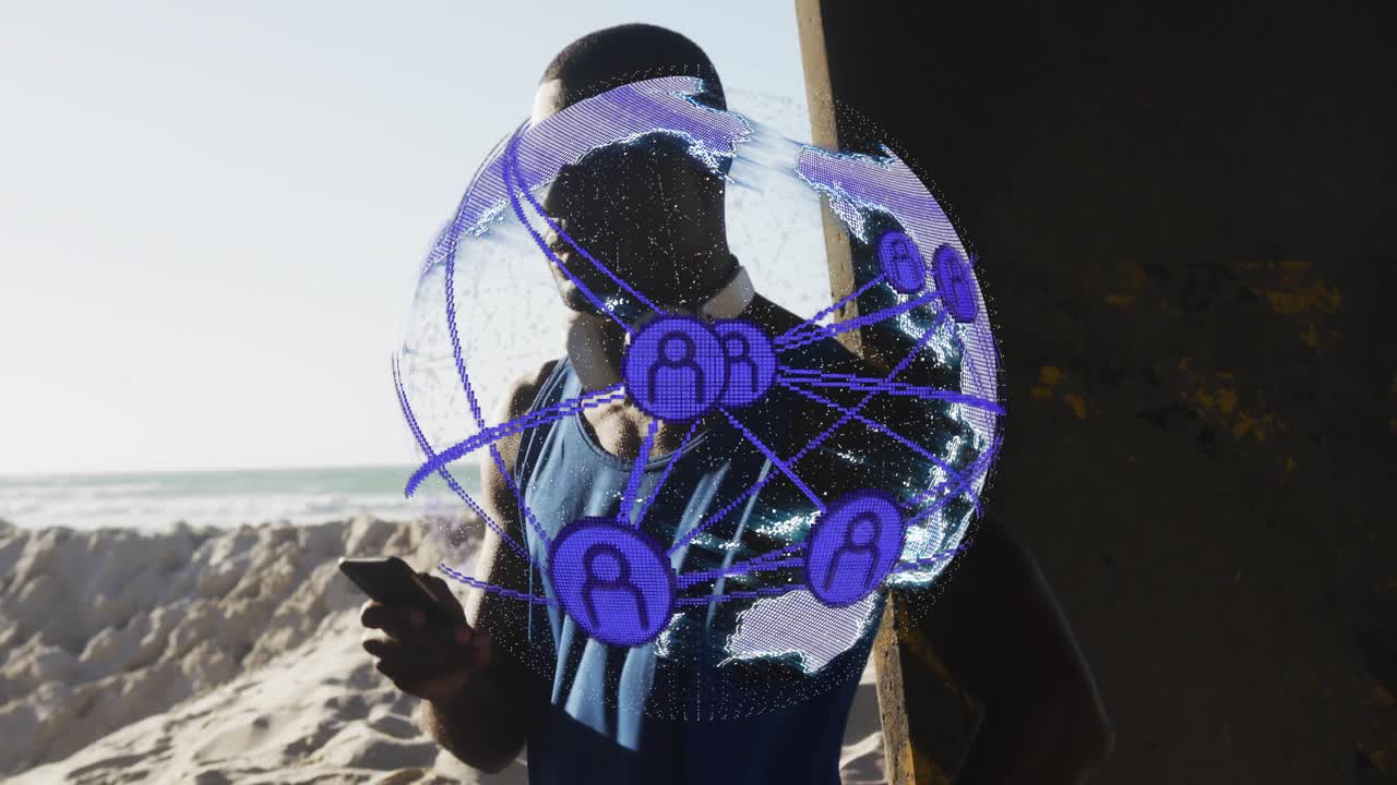 Man standing on beach beside concrete pillar, using smartphone showing tech with AR network globe