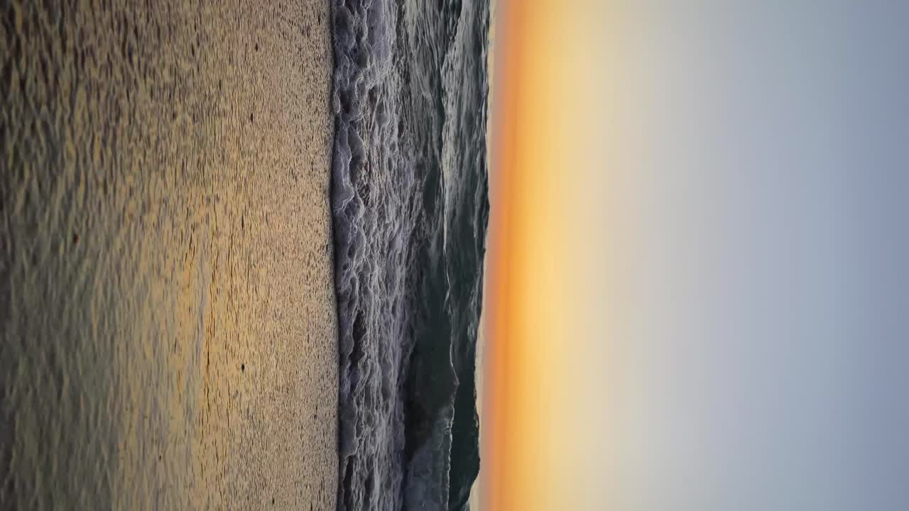 tiro vertical de las olas del mar salpicando en la orilla con el cielo de la puesta de sol en el fondo en anfeh, líbano