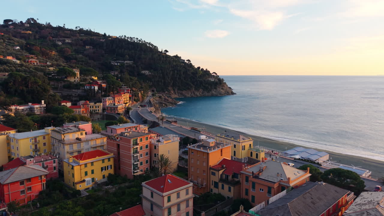Drone si allontana sopra Bonassola, rivelando spiaggia, mare, scogliere e colline