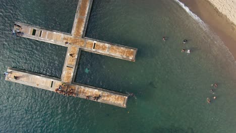 niños locales jugando en imágenes de aviones no tripulados de arriba hacia abajo del muelle