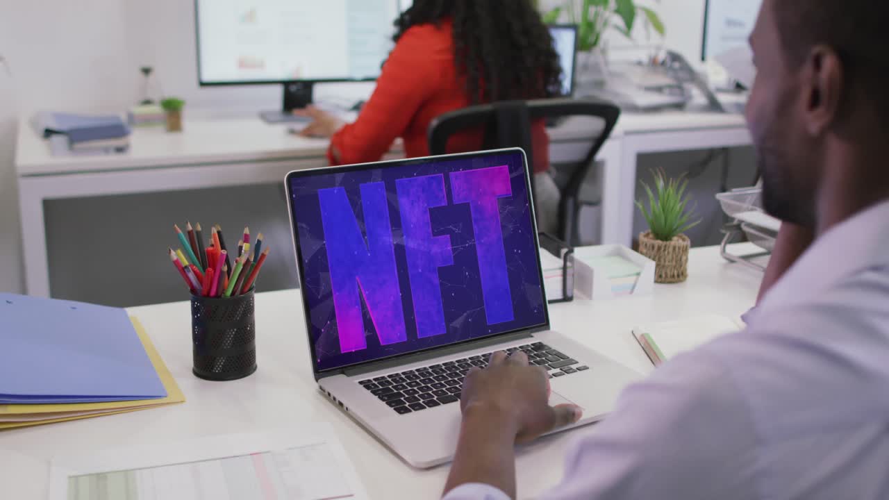 video de un hombre afroamericano trabajando en una computadora portátil con nft en la pantalla