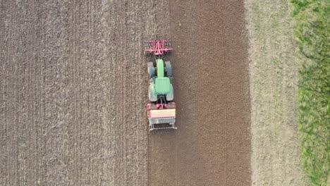 tractor with seed drill and front packer compacts the soil