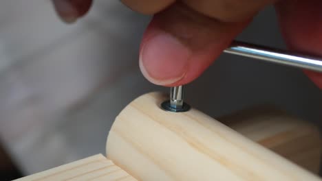 hand assembling wooden furniture with screwdriver