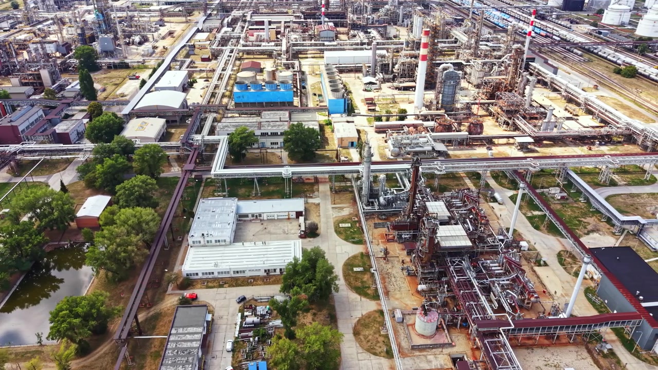 Vista a volo d'uccello di un'area industriale con vari edifici e tubature in una città di giorno