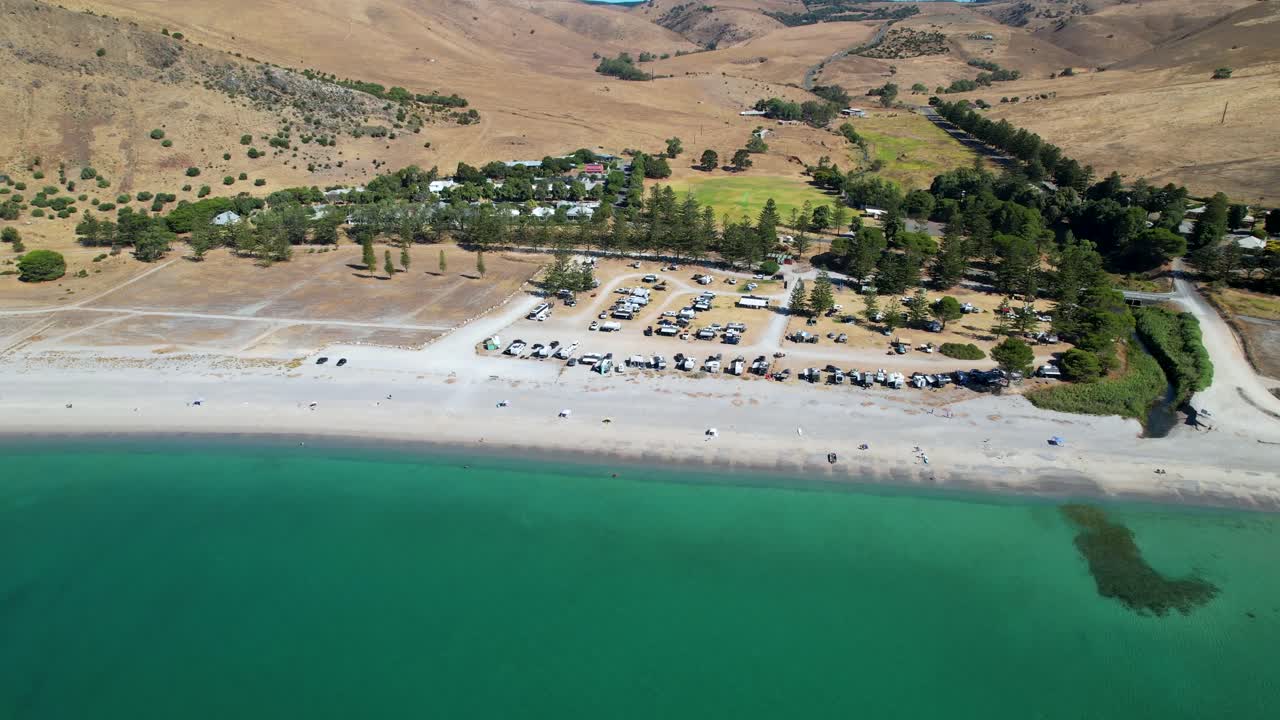 una toma de un dron de 4k volando hacia adelante y panorámica para revelar rapid bay, un popular campamento en el sur de australia en una hermosa playa de arena blanca que mira hacia un brillante océano turquesa