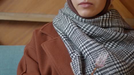 a woman wearing a hijab and a brown coat