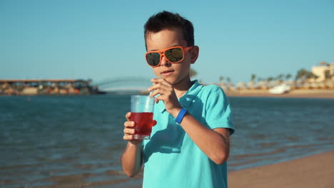 joven atractivo con gafas de sol disfrutando de las vacaciones de verano en la soleada playa.