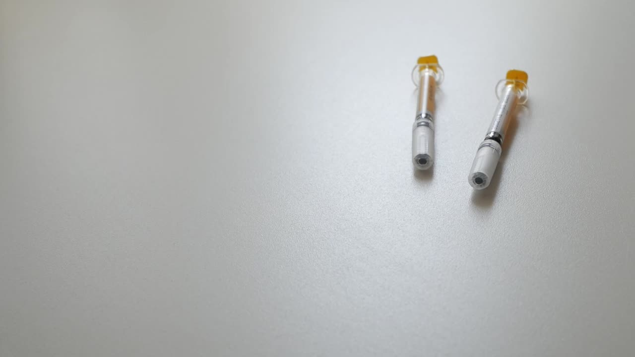 Hands holding a syringe, preparing for medical use with a focused atmosphere