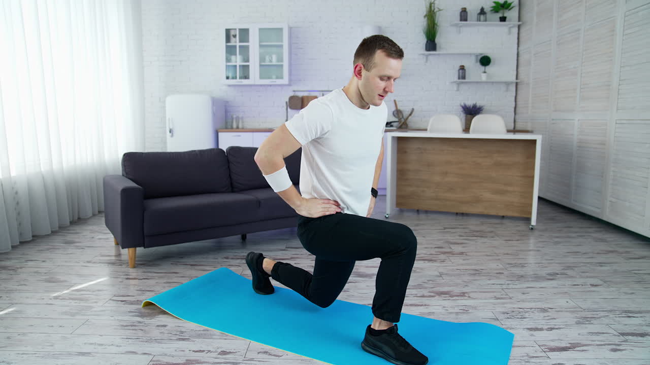 Guy is exercising on a mat at home. Young man holding balance during workout. Home fitness, training and wellness concept. Quarantine.