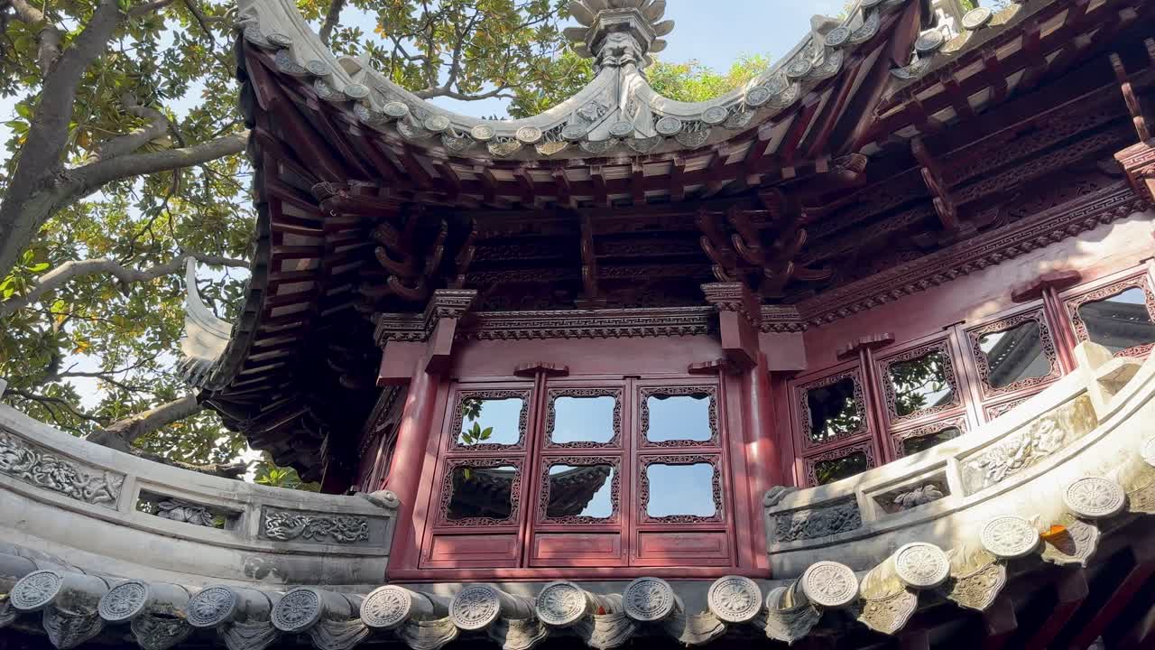 Traditional Yu Garden structure framed by bright sky and lush trees