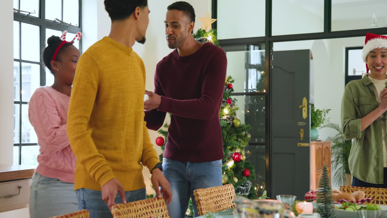 diverse friends celebrating Christmas at home, setting table with festive cheer and smiles