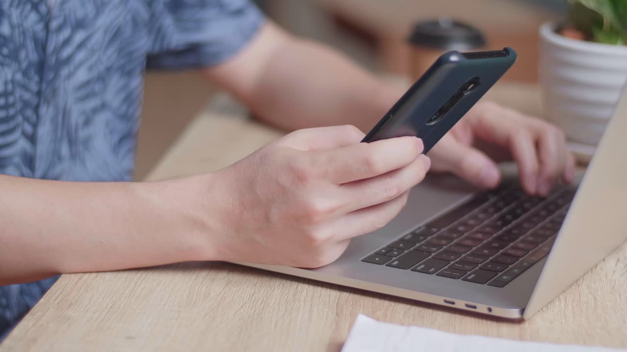 Close Up Hands Man Using Mobile Phone During Work On Laptop Computer, Video In 4K