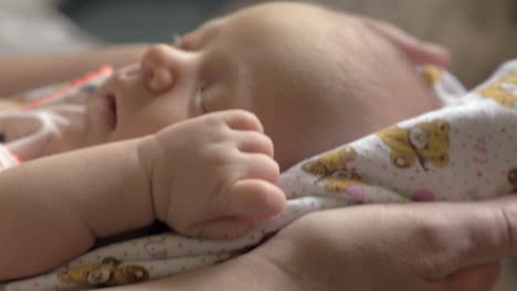 la abuela balanceando al bebé durmiendo en el regazo