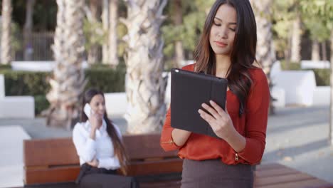 Young-businesswoman-using-a-tablet-outdoors