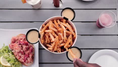 amigos disfrutan juntos de un balde de papas fritas