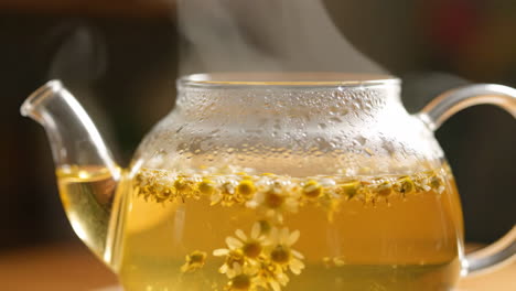 Chamomile tea in a glass teapot