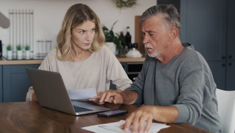 caucasian senior man and adult daughter counting home finance.