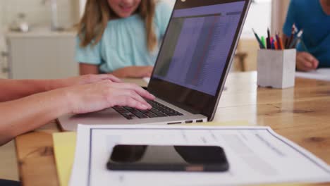 sección media de la mujer usando computadora portátil mientras trabaja desde casa