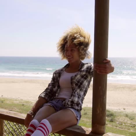 young woman sitting on a beachfront balcony