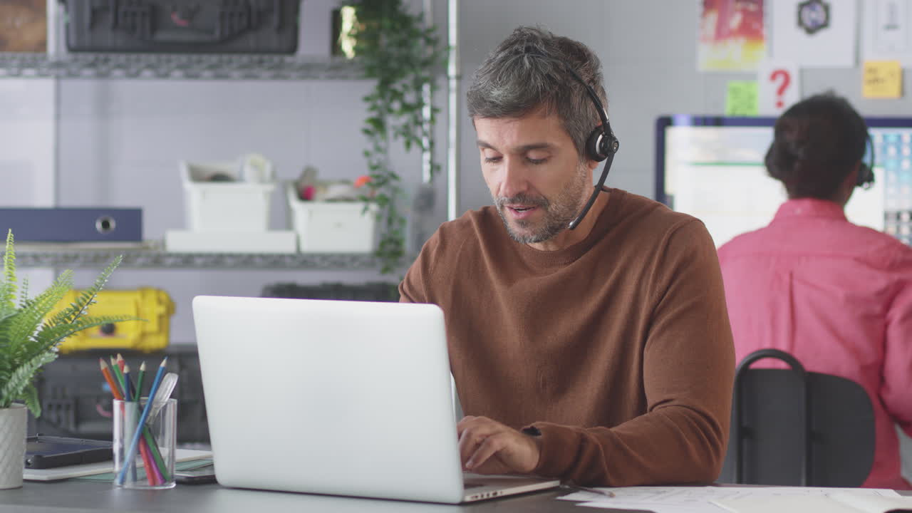Forretningsmand med telefonheadset taler med kunde i kundeservice callcenter
