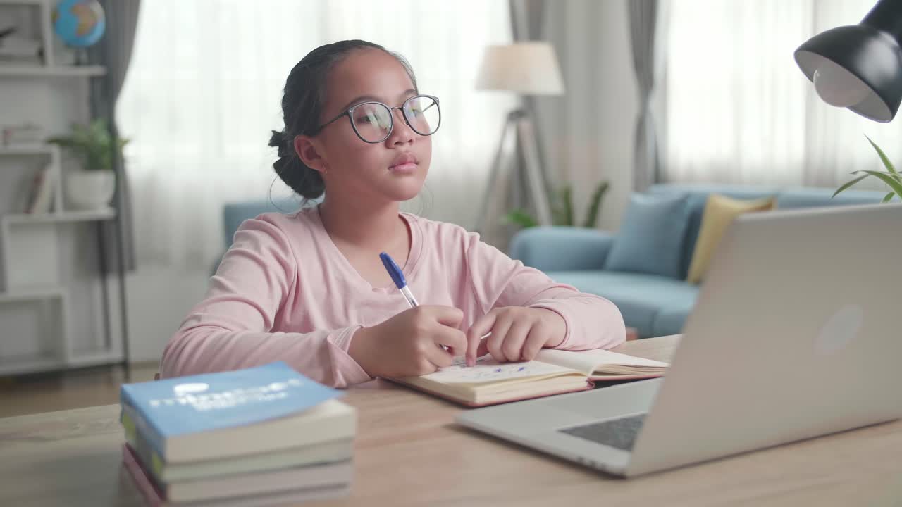 Teenage Girl With Laptop Doing Homework At Living Room