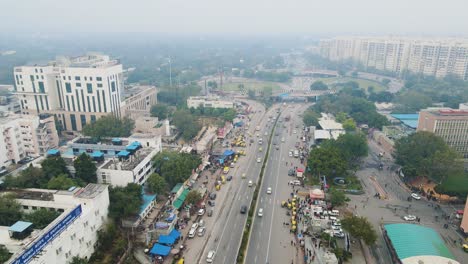 aerial drone shot showcasing the chaotic yet organized flow of cars, buses, and motorcycles on a busy flyover in delhi.