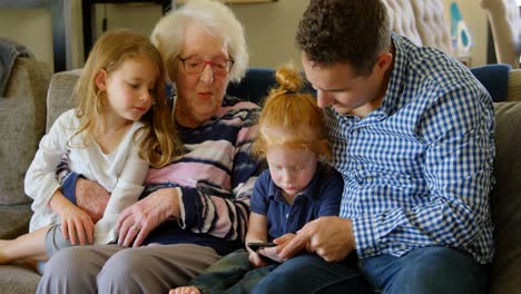 family using mobile phone in living room 4k