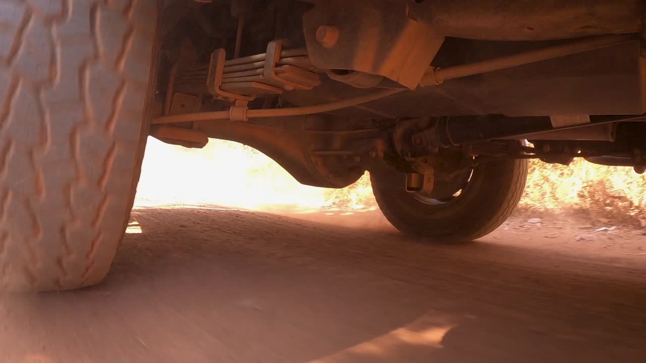 el sistema de transmisión de las ruedas traseras del camión ligero de tracción fuera de carretera de 4 ruedas que conduce en terreno sucio y polvoriento