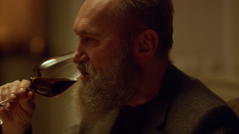 Closeup-smiling-senior-man-drinking-red-wine-glass