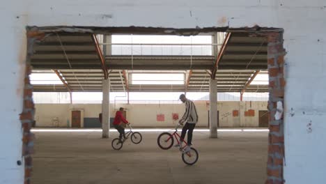 jinetes de bmx en un almacén vacío