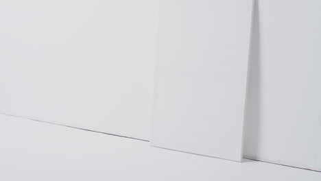 Vertical-video-of-white-canvas-sign-with-copy-space-on-floor-against-white-background