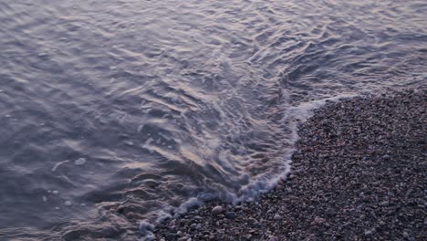 Nahaufnahme-Von-Oben,-Schäumende-Wellen,-Die-Kieselsteine-Spritzen,-Friedlicher-Naturhintergrund