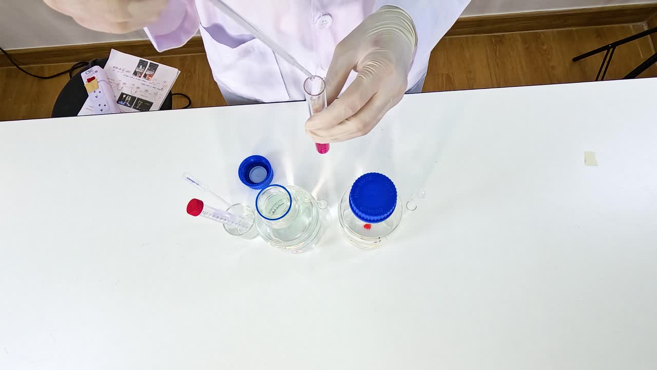 Scientist conducts a potassium permanganate reduction experiment on a white table with clear containers and precise movements