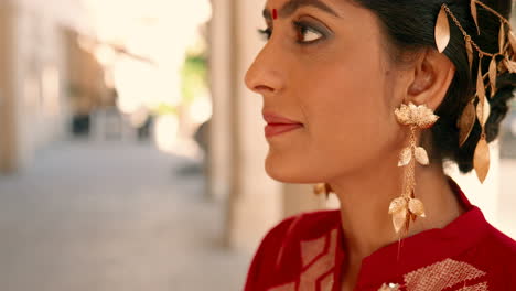 close-up of beautiful indian woman smelling a bottle of perfume