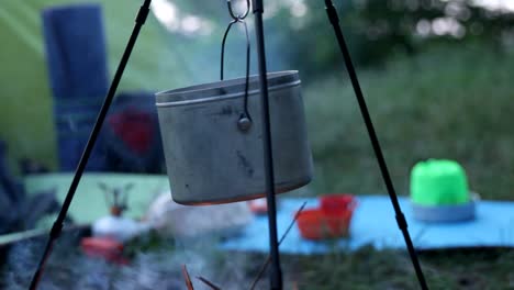 pan with water on a tripod over the fire