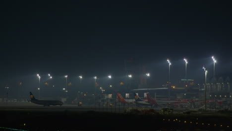 night time view of an airport with airplanes on the runway