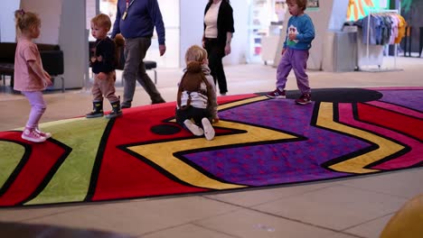 los niños interactúan en el colorido piso del museo.