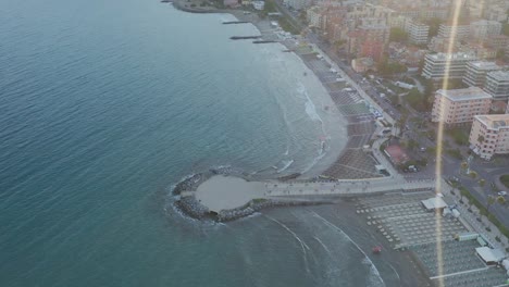 drone shot revealing the ligurian coast and the city of andora during sunset